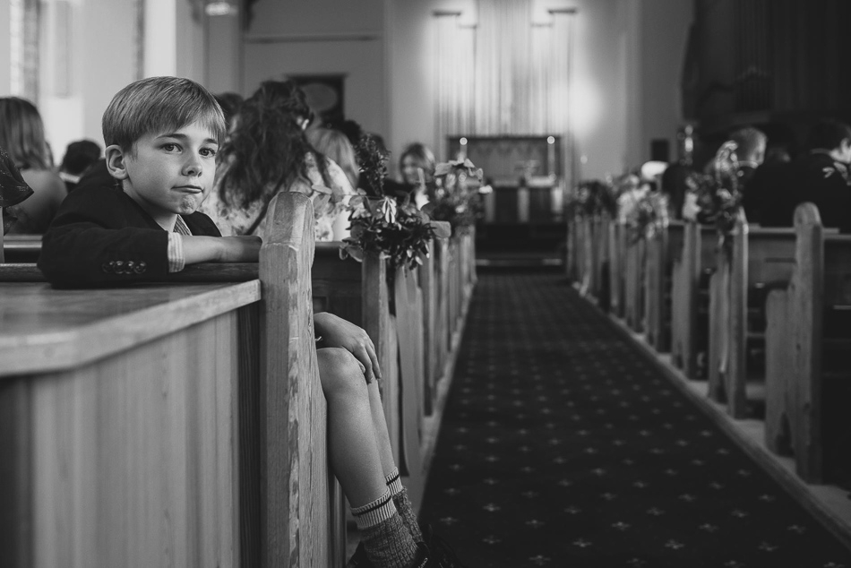 Boy looking at the camera in church at a wedding in Jersey, Channel Islands