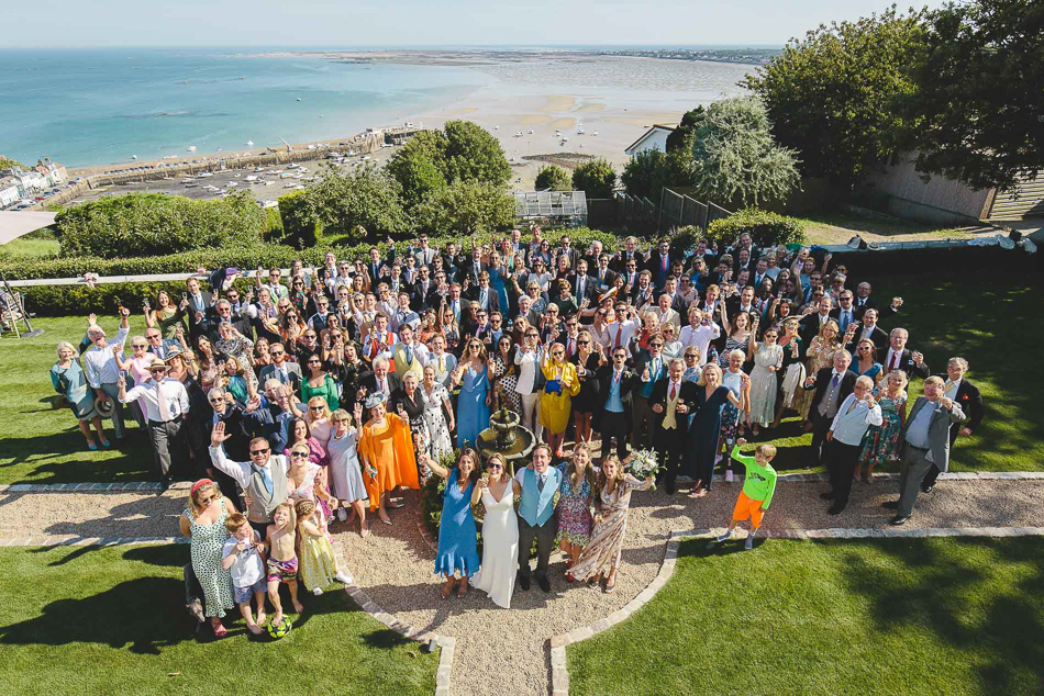 Group photo of wedding guests overlooking Gorey at a wedding in Jersey, Channel Islands