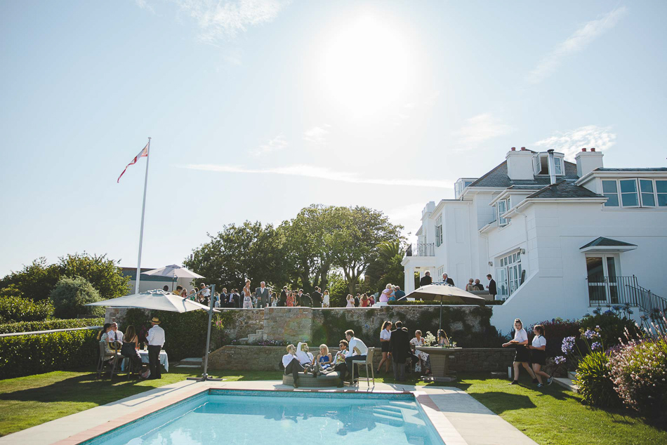 Wedding guests by the pool at a wedding in Jersey, Channel Islands