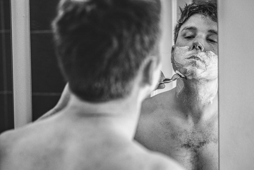 Groom reflection mirror while shaving