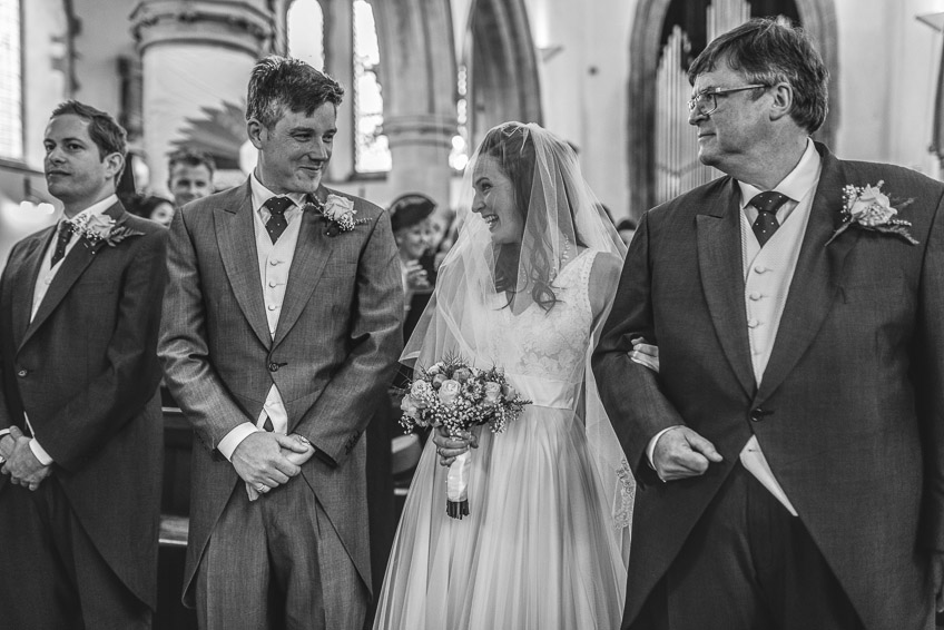 bride and groom smile at each other during ceremony