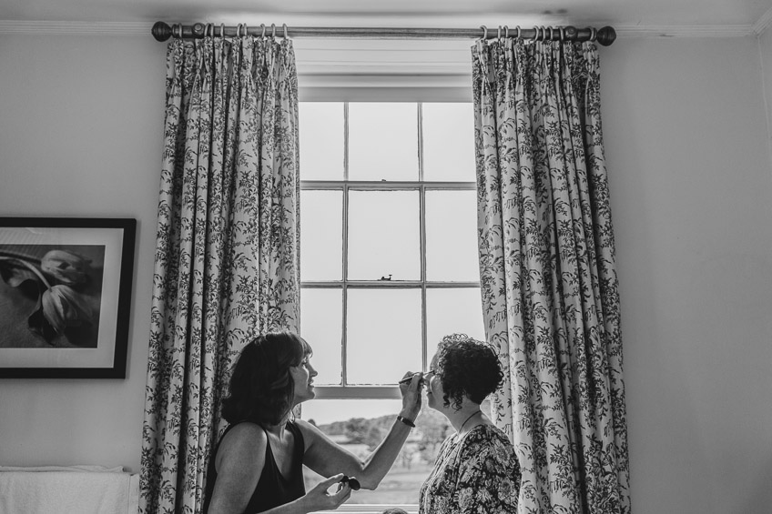 Bride having make up applied in the window