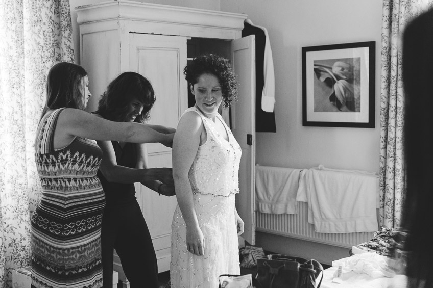 bride having her dress buttoned up