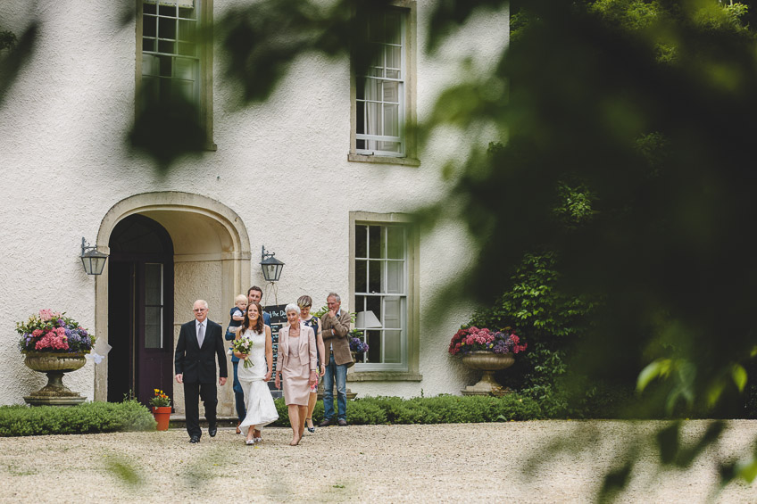 Bride walking out of house